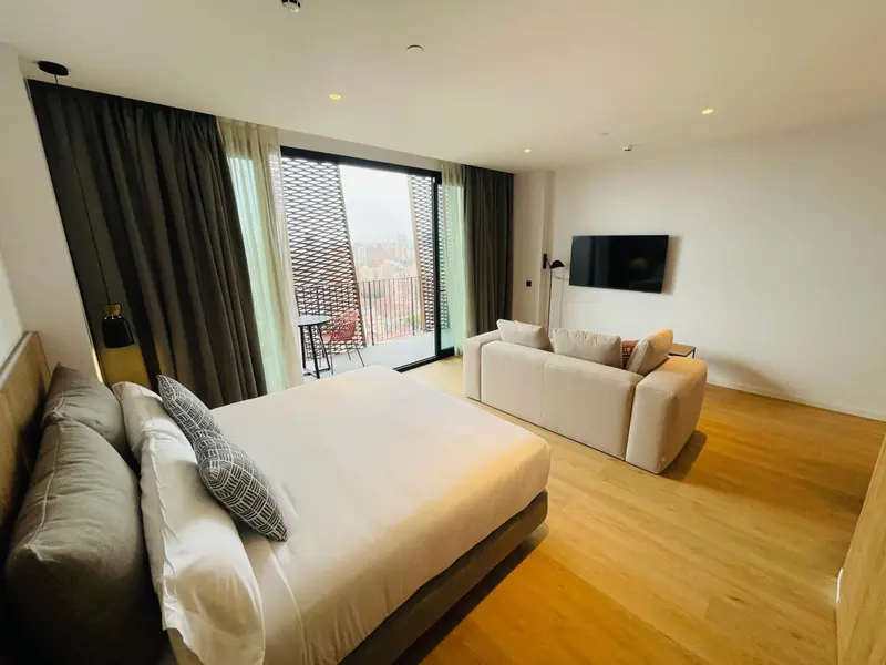 Une chambre lumineuse avec un grand lit et un coin salon.