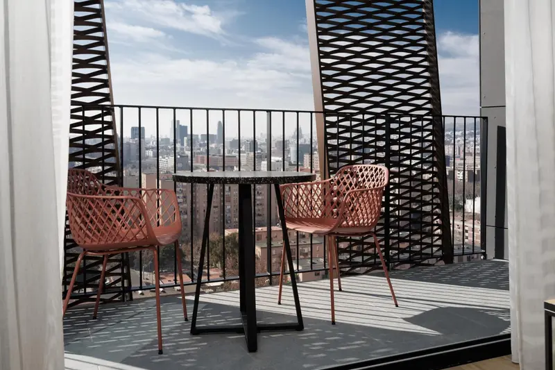 Terrasse avec mobilier de jardin et vue sur la ville.