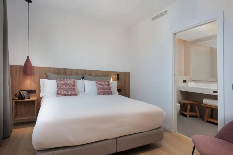 Une chambre lumineuse avec un grand lit et un espace détente.