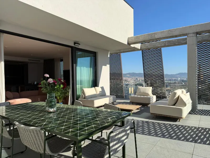 Une table à manger est mise en scène sur une terrasse avec vue sur la ville.
