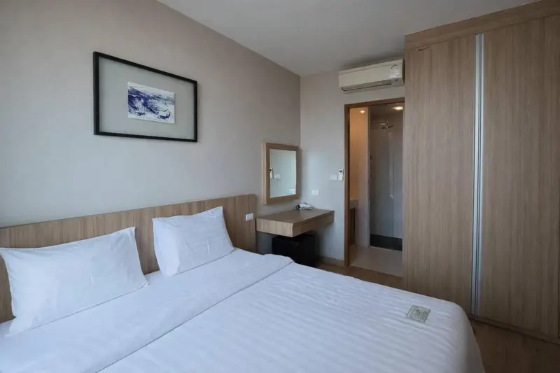 Une chambre lumineuse avec un grand lit et un espace rangement.