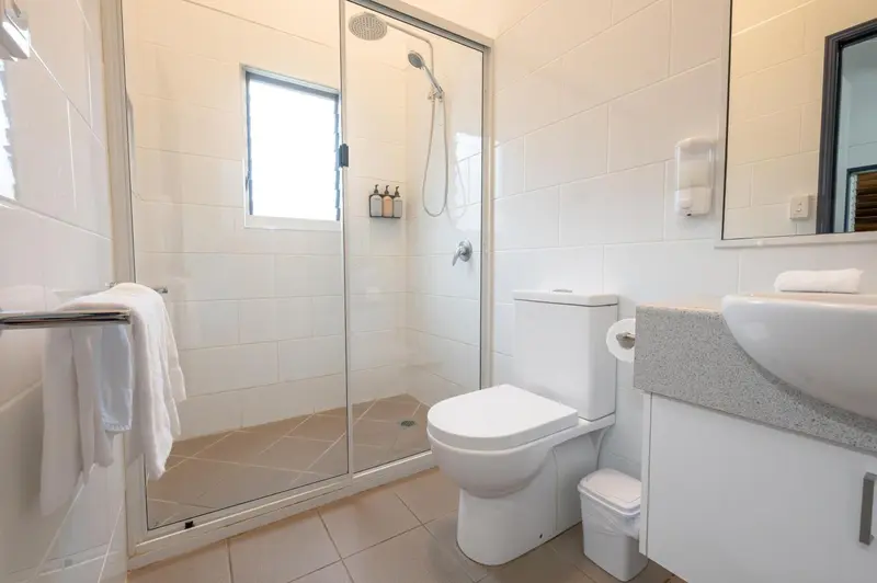Une salle de bain claire avec douche à l'italienne et lavabo.