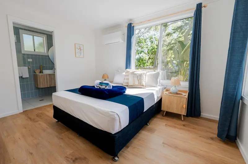 Une chambre lumineuse avec un grand lit et un accès à une salle de bain.
