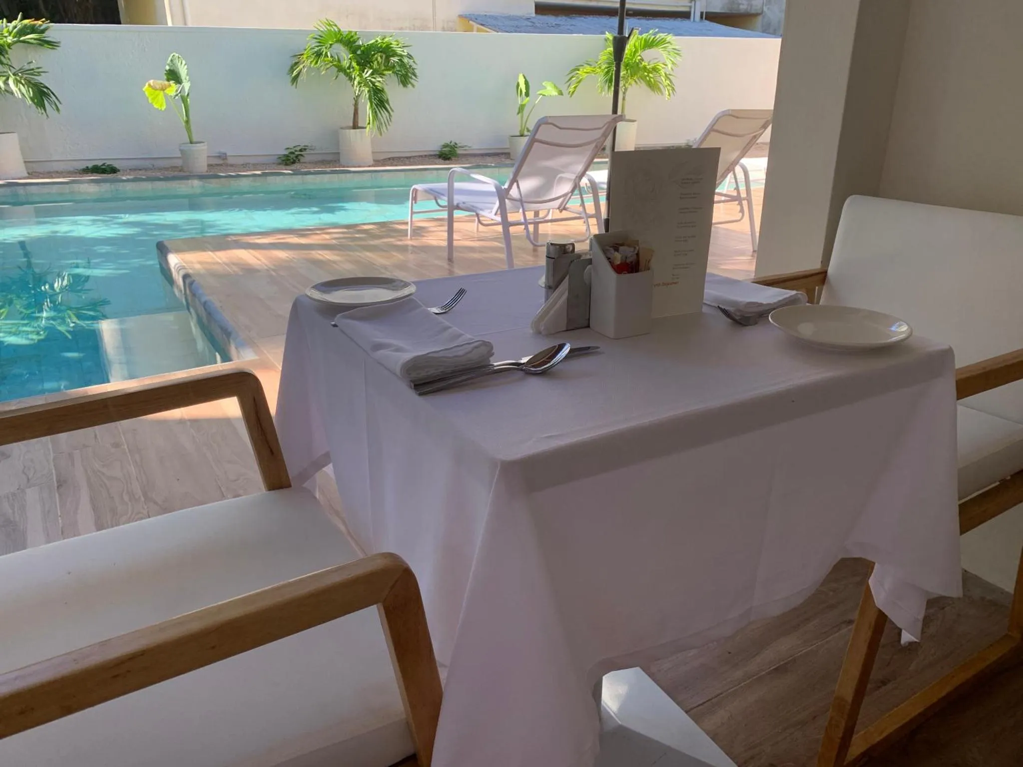 Table dressée à l'extérieur près d'une piscine.