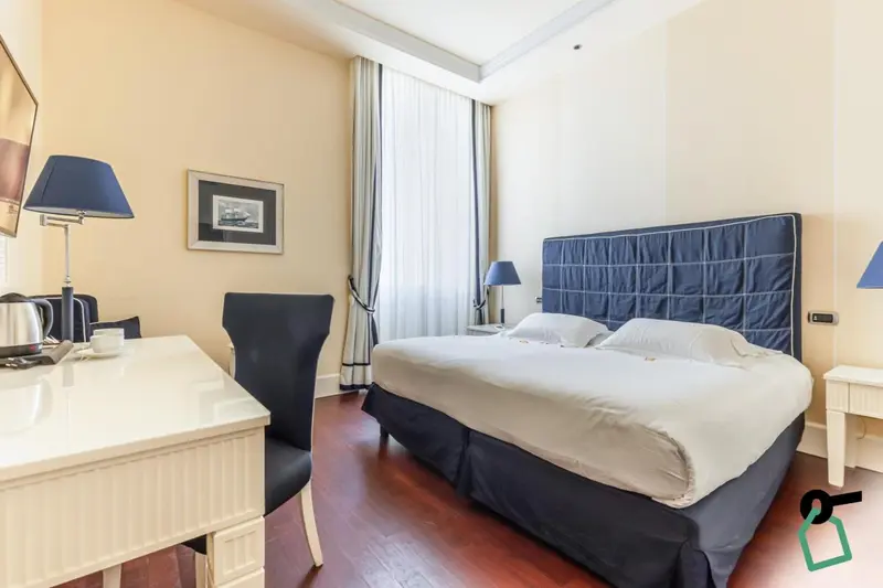Une chambre lumineuse avec un grand lit et un bureau.