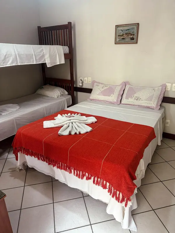 Une chambre avec deux lits superposés et un lit double.