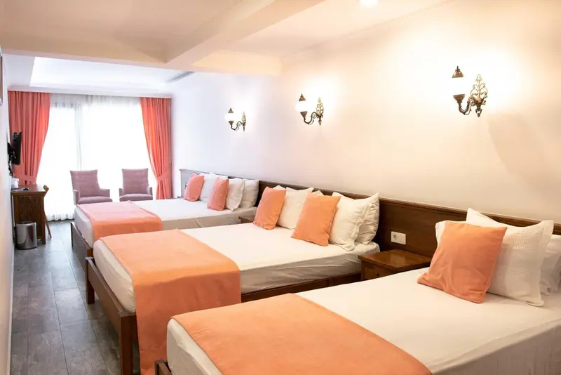 Une chambre lumineuse avec deux lits simples et un canapé.