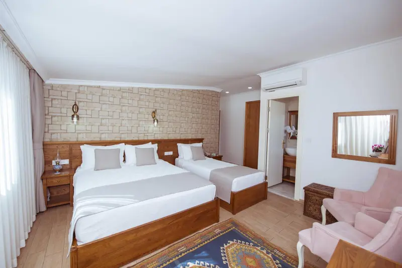Une chambre lumineuse avec deux lits et un coin salon.
