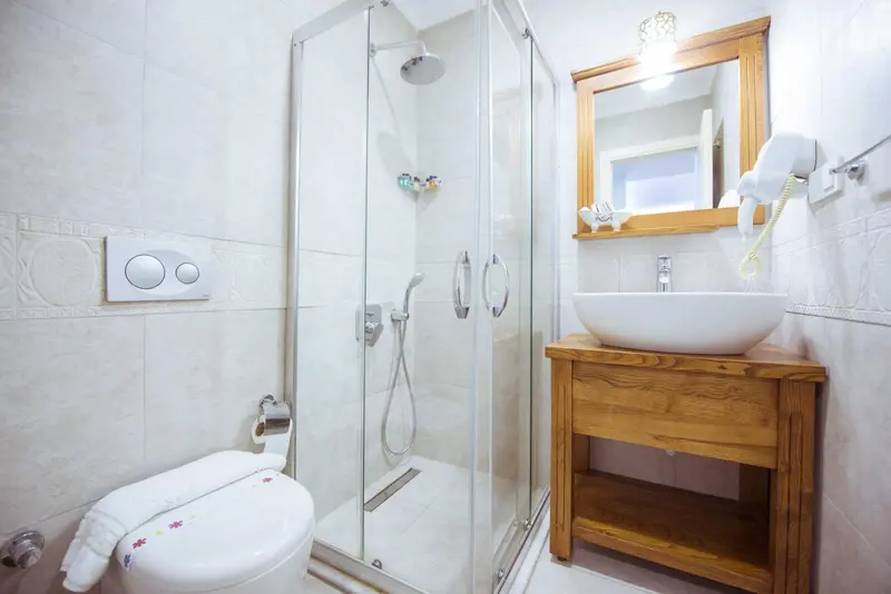 Une salle de bain moderne avec douche à l'italienne et lavabo sur meuble en bois.