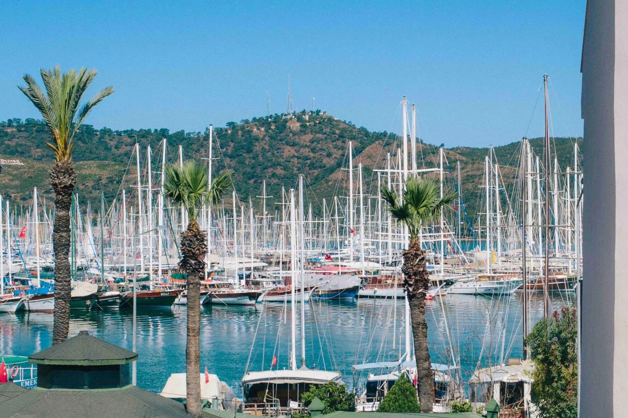 Vue d'un port de plaisance avec de nombreux voiliers amarrés au bord de l'eau.