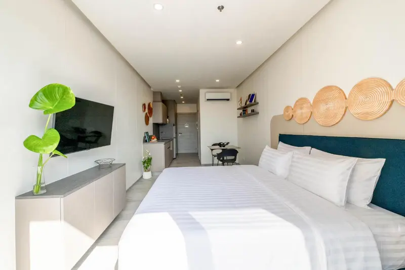 Une chambre lumineuse avec un lit double et un coin repas.