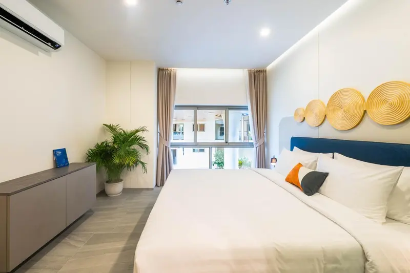Une chambre lumineuse avec un grand lit et une vue sur l'extérieur.