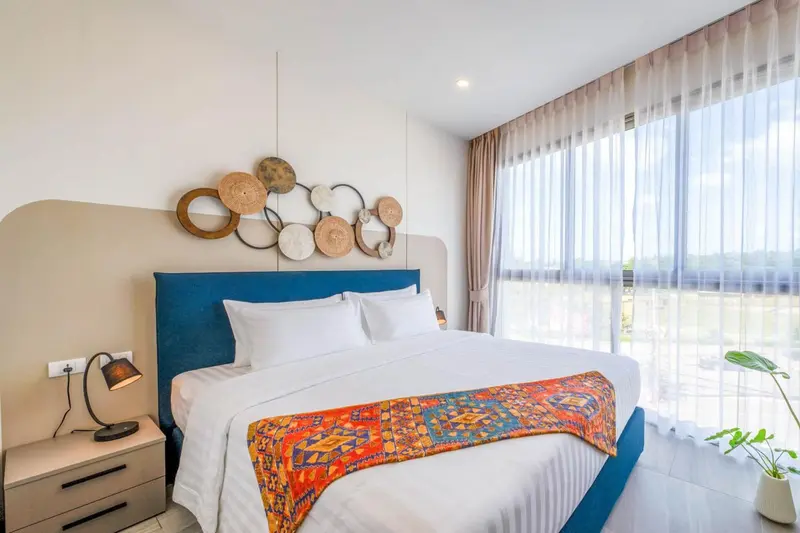 Une chambre lumineuse avec un grand lit et une décoration murale.