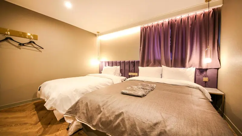 Une chambre avec deux lits simples et une décoration sobre.