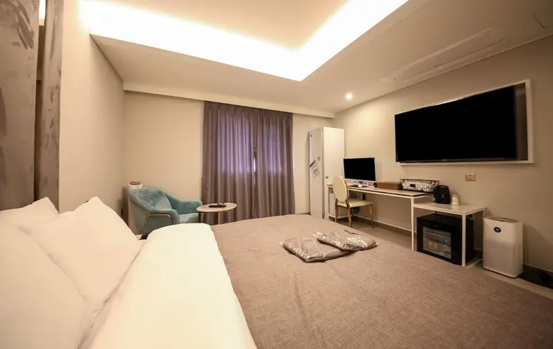 Une chambre lumineuse avec un grand lit et un espace bureau.