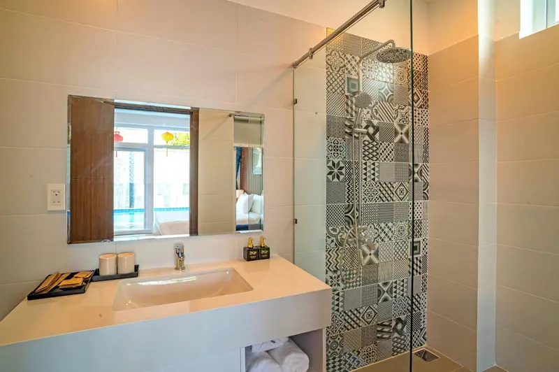 Une salle de bain lumineuse avec une douche à l'italienne et un lavabo.