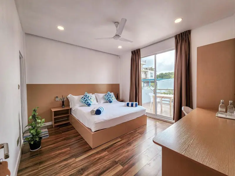 Une chambre lumineuse avec un grand lit et un bureau.