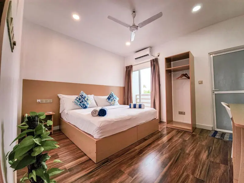 Une chambre lumineuse avec un grand lit et un accès à une terrasse.
