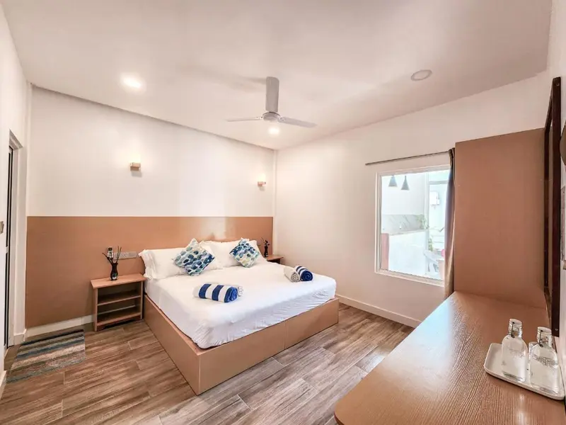 Une chambre lumineuse avec un grand lit et une fenêtre.