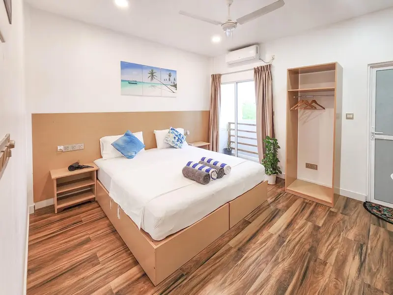Une chambre lumineuse avec un grand lit et un accès à une terrasse.