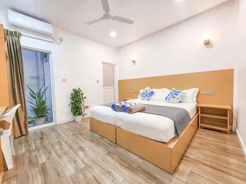 Une chambre lumineuse avec un grand lit et une décoration sobre.
