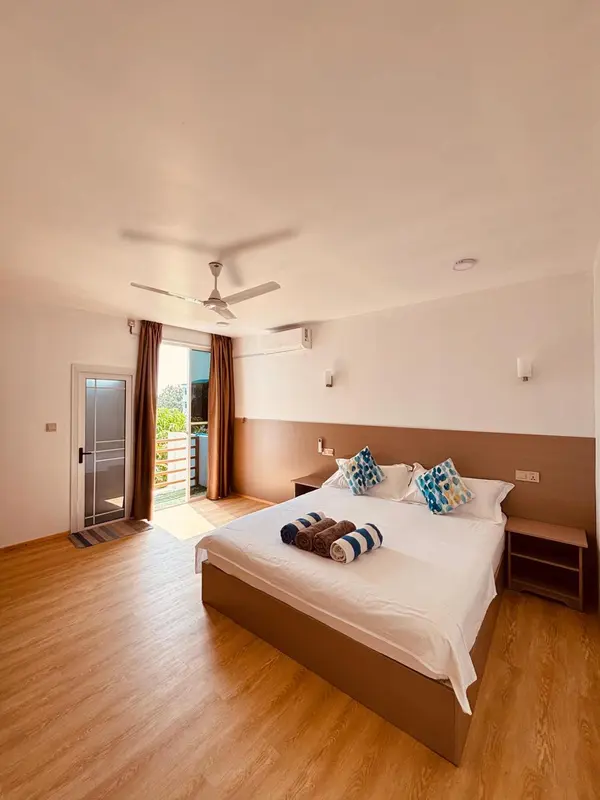 Une chambre lumineuse avec un grand lit et un accès à une terrasse.