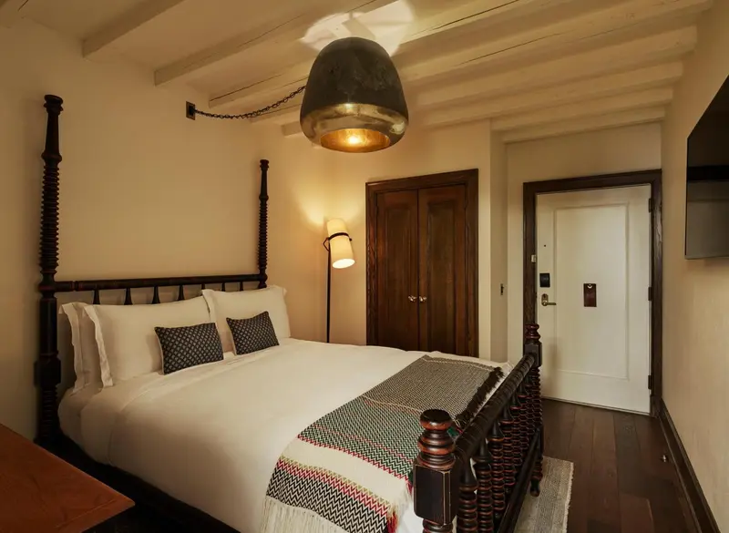 Une chambre à coucher avec un lit à baldaquin et une décoration sobre.