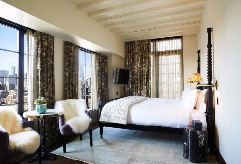 Une chambre lumineuse avec un grand lit et des fauteuils confortables.