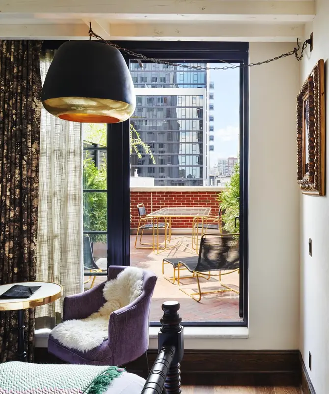 Une terrasse aménagée avec des tables et des chaises offre une vue sur la ville.