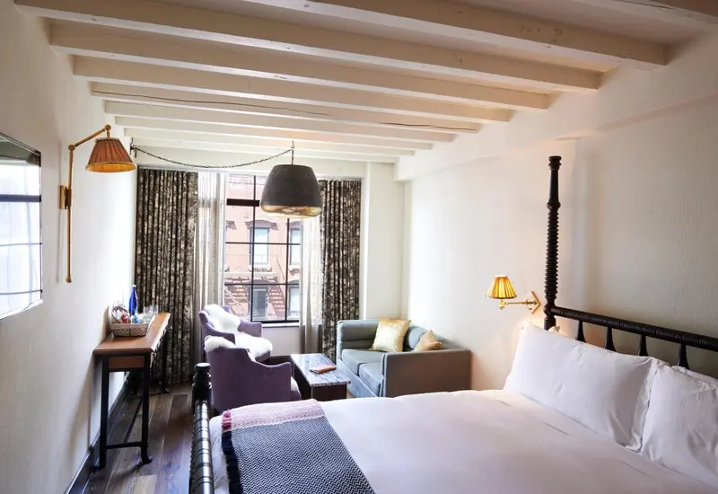 Une chambre lumineuse avec un lit et un coin salon.
