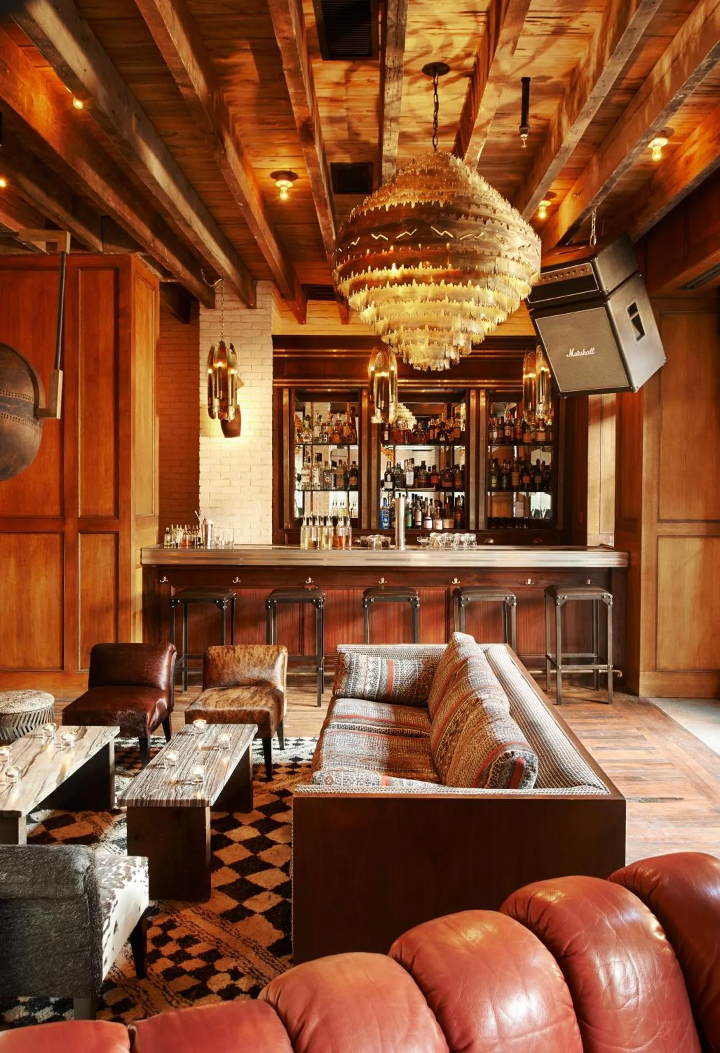Un espace de détente avec un bar en fond et des canapés en cuir.