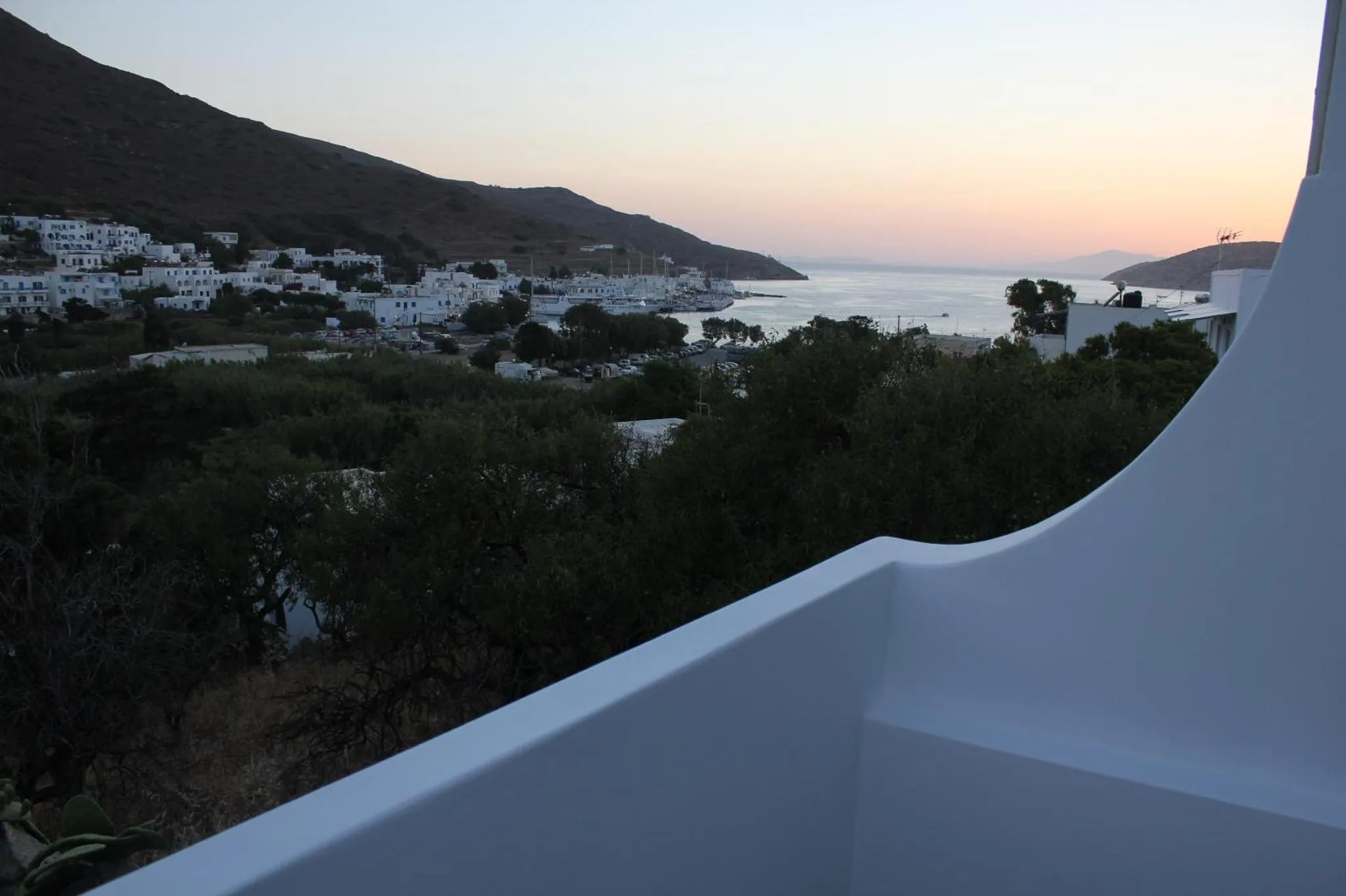 Vue panoramique sur un village côtier et la mer au crépuscule.