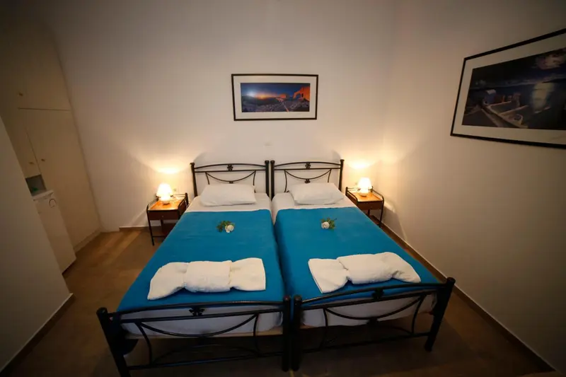Une chambre lumineuse avec deux lits simples et une décoration sobre.