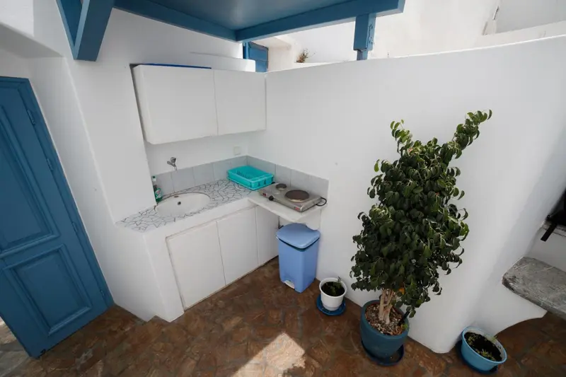Une petite cuisine d'été avec un plan de travail et une plaque de cuisson.