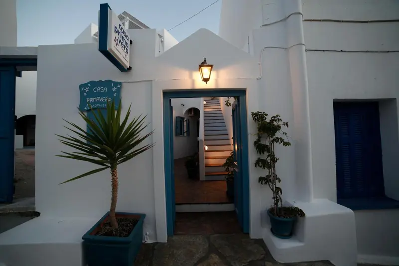 Entree d'une maison blanche avec un escalier menant a l'etage.