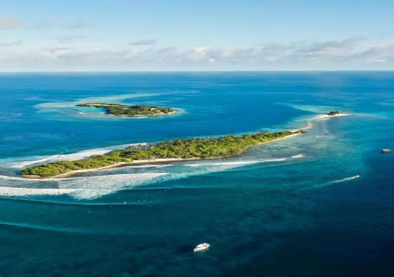 Vue aérienne d'îles tropicales entourées d'eaux turquoise et de récifs coralliens.