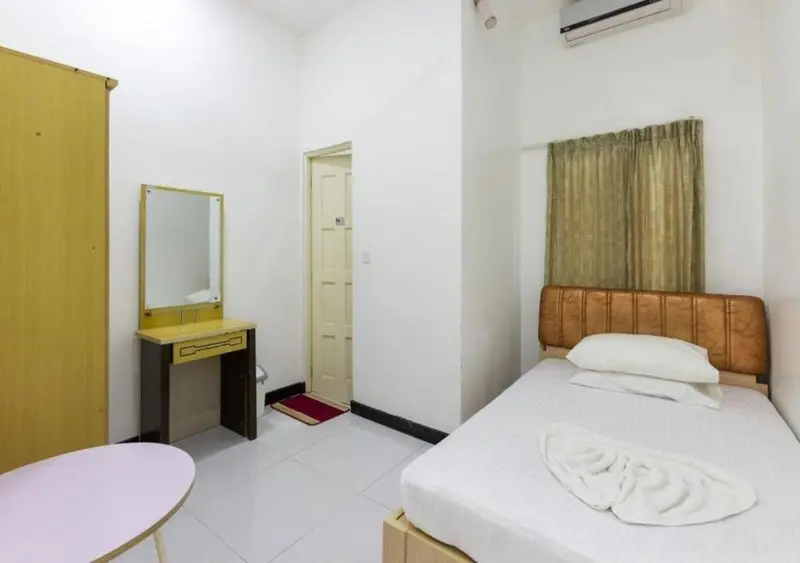 Une chambre simple avec un lit et une coiffeuse.