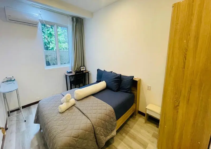 Une chambre avec un lit recouvert d'une couette et de coussins.