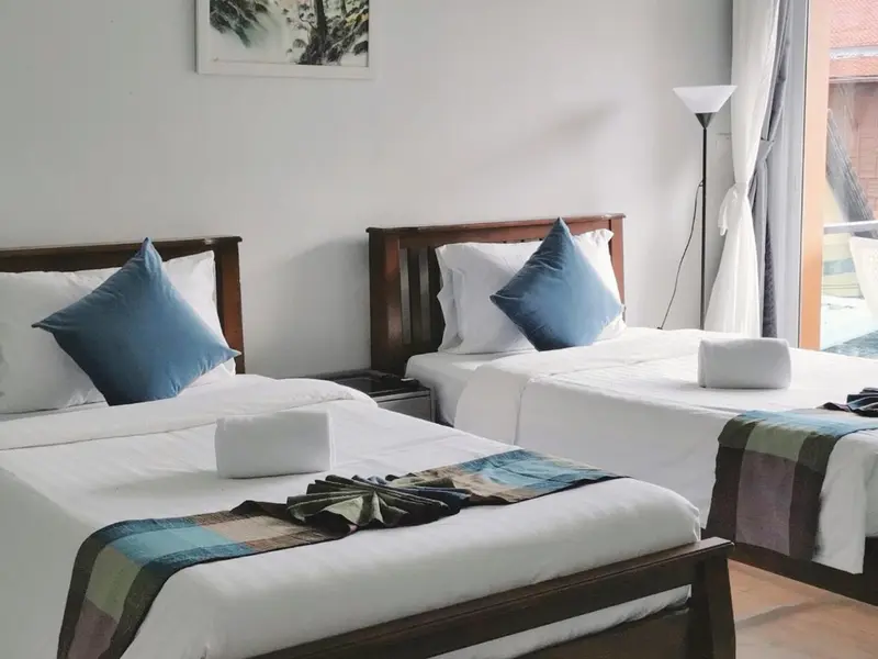 Chambre avec deux lits simples et une décoration sobre.