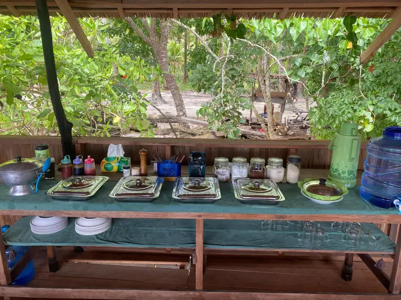 Un buffet propose une variété de plats et de boissons dans un espace extérieur abrité.