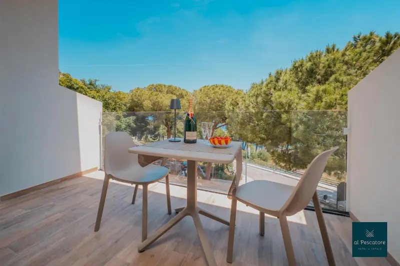 Une table et deux chaises sur un balcon avec vue sur la végétation.