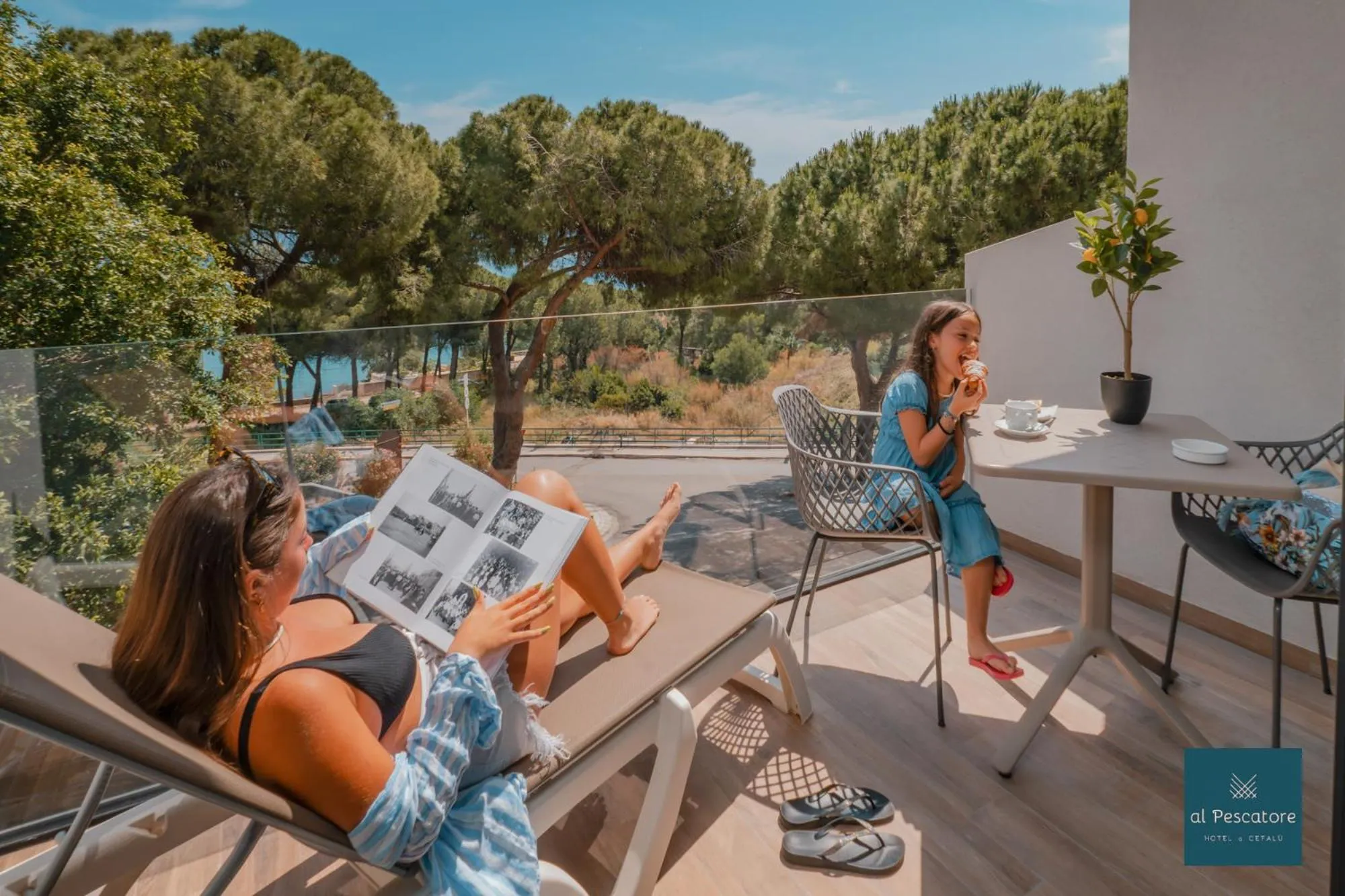 Deux femmes se détendent sur une terrasse ensoleillée avec vue sur la mer.
