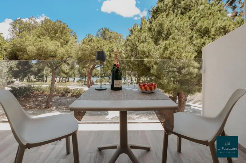 Une table avec des verres et une bouteille de champagne sur une terrasse ensoleillée.