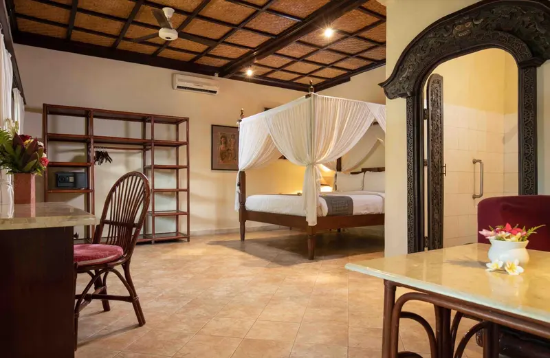 Une chambre avec un lit à baldaquin et un coin repas.