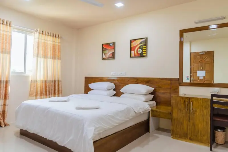 Une chambre lumineuse avec un grand lit et des tableaux décoratifs.