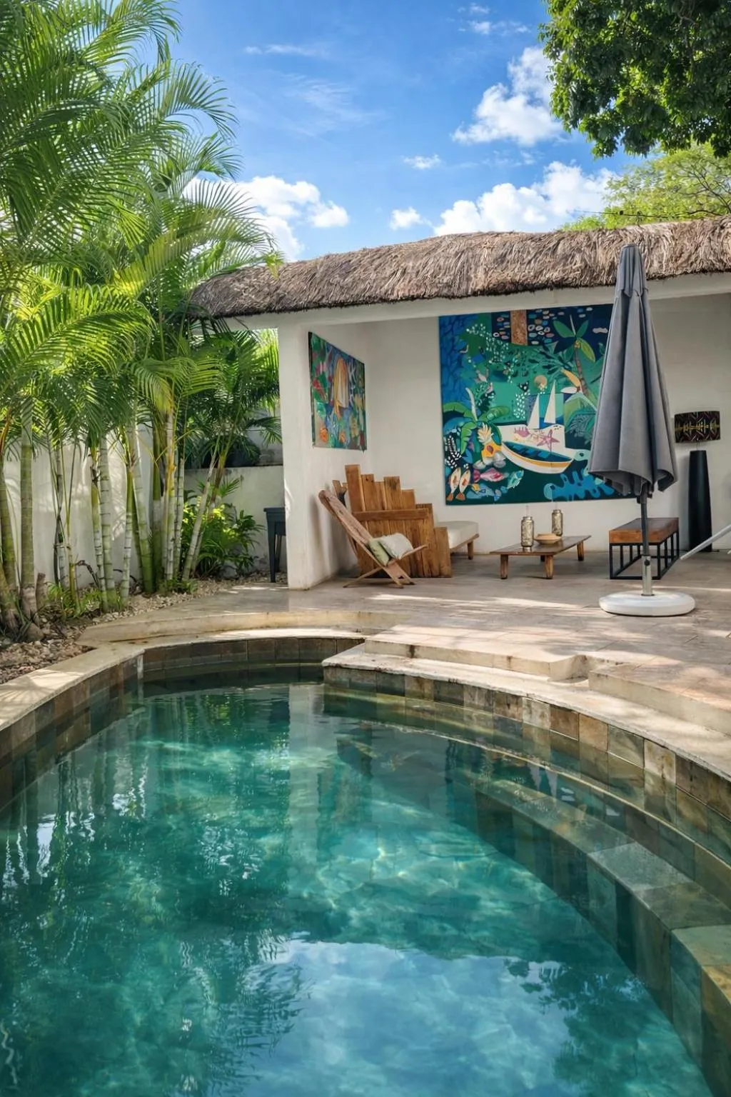 Une piscine rectangulaire avec un espace de détente ombragé à proximité.