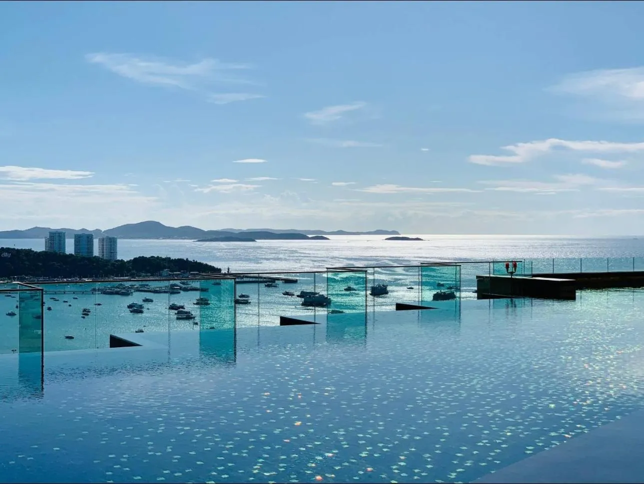 Une piscine à débordement offre une vue sur la mer et les îles au loin.