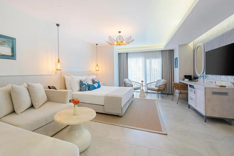 Une chambre lumineuse avec un grand lit et un coin salon.
