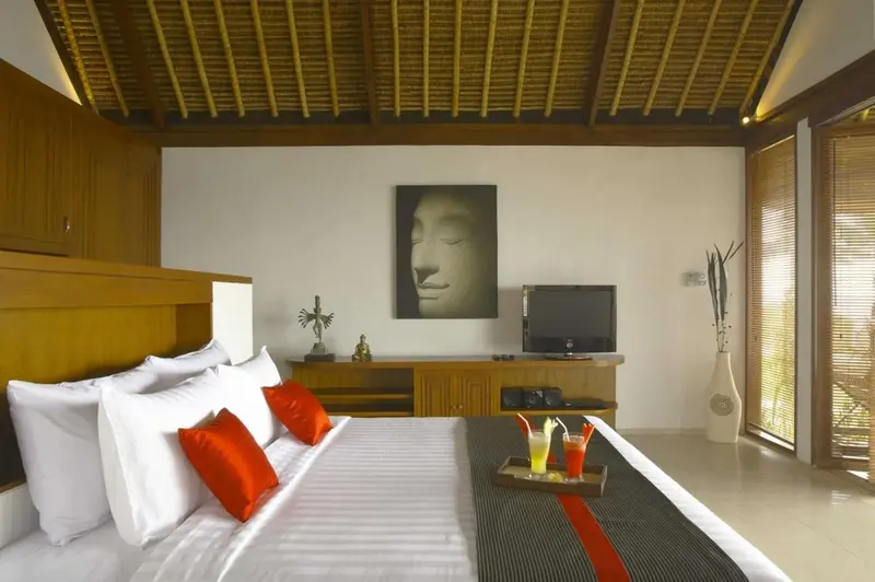 Une chambre lumineuse avec un grand lit et une décoration zen.