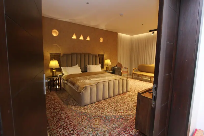 Une chambre à coucher spacieuse avec un grand lit et un coin salon.
